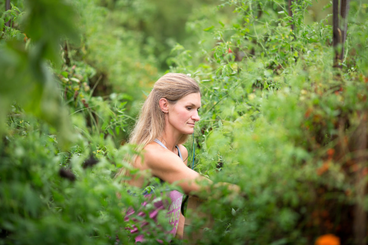 Ashley Grouch of The Farm Life Movement tending her veggies on her regenerative farm