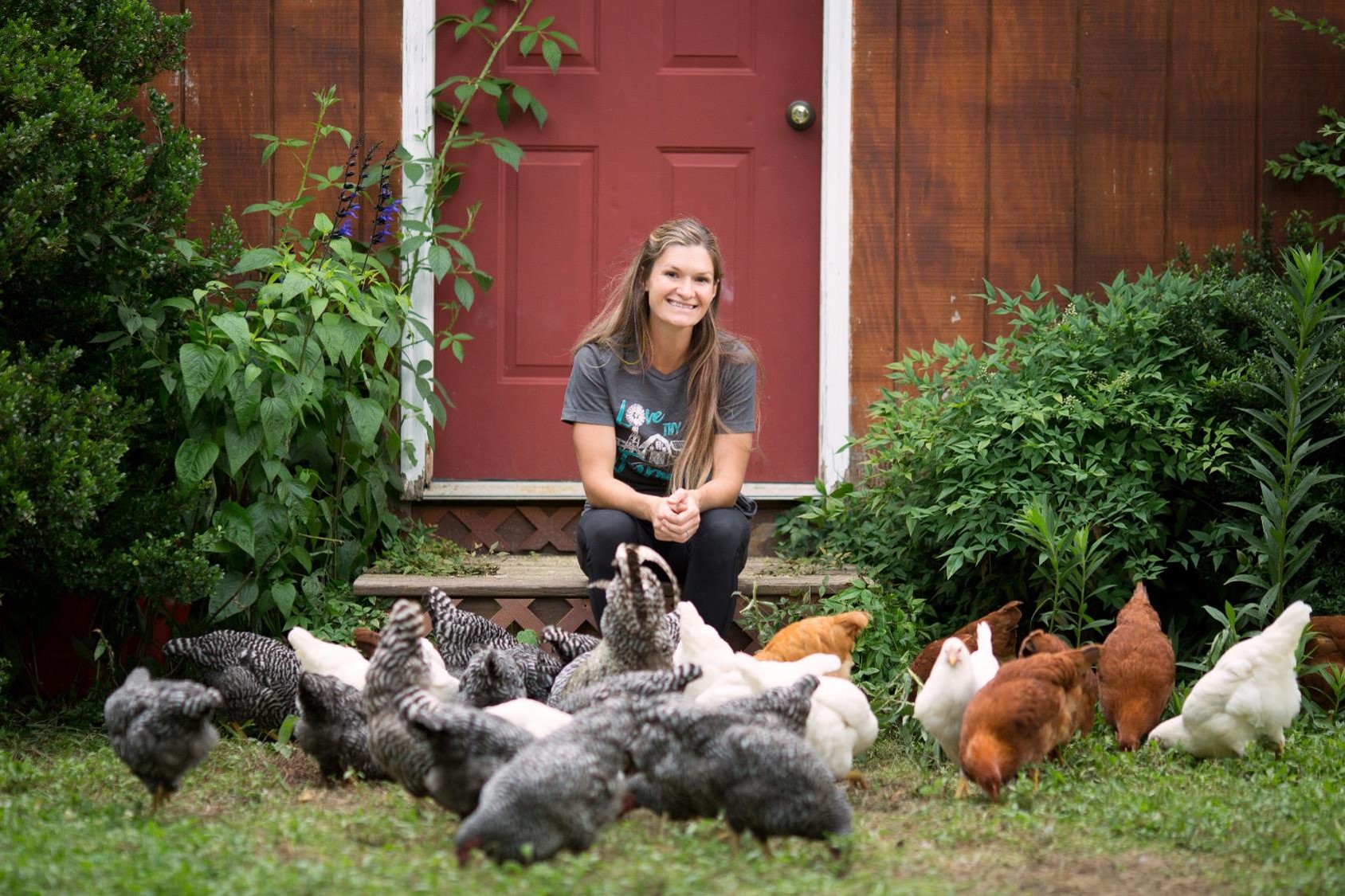 Ashley Grouch of The Farm Life Movement with chickens on her regenerative farm