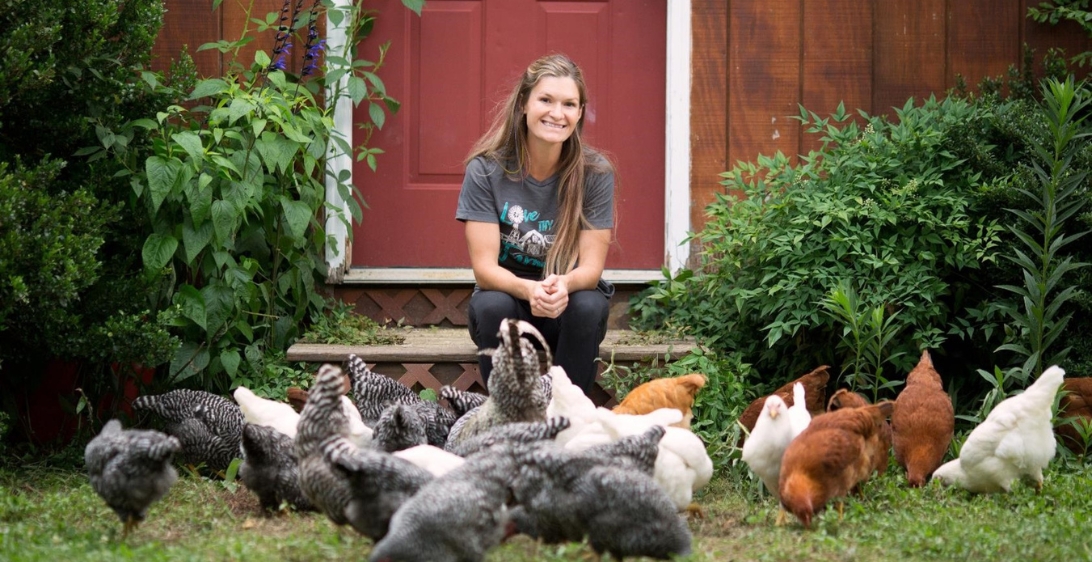 Ashley Grouch of The Farm Life Movement with chickens on her regenerative farm